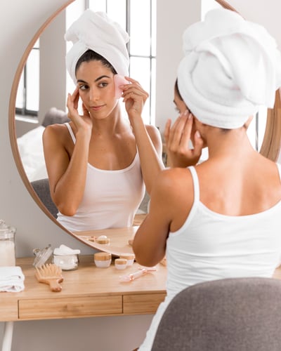 woman-with-towel-looking-into-mirror